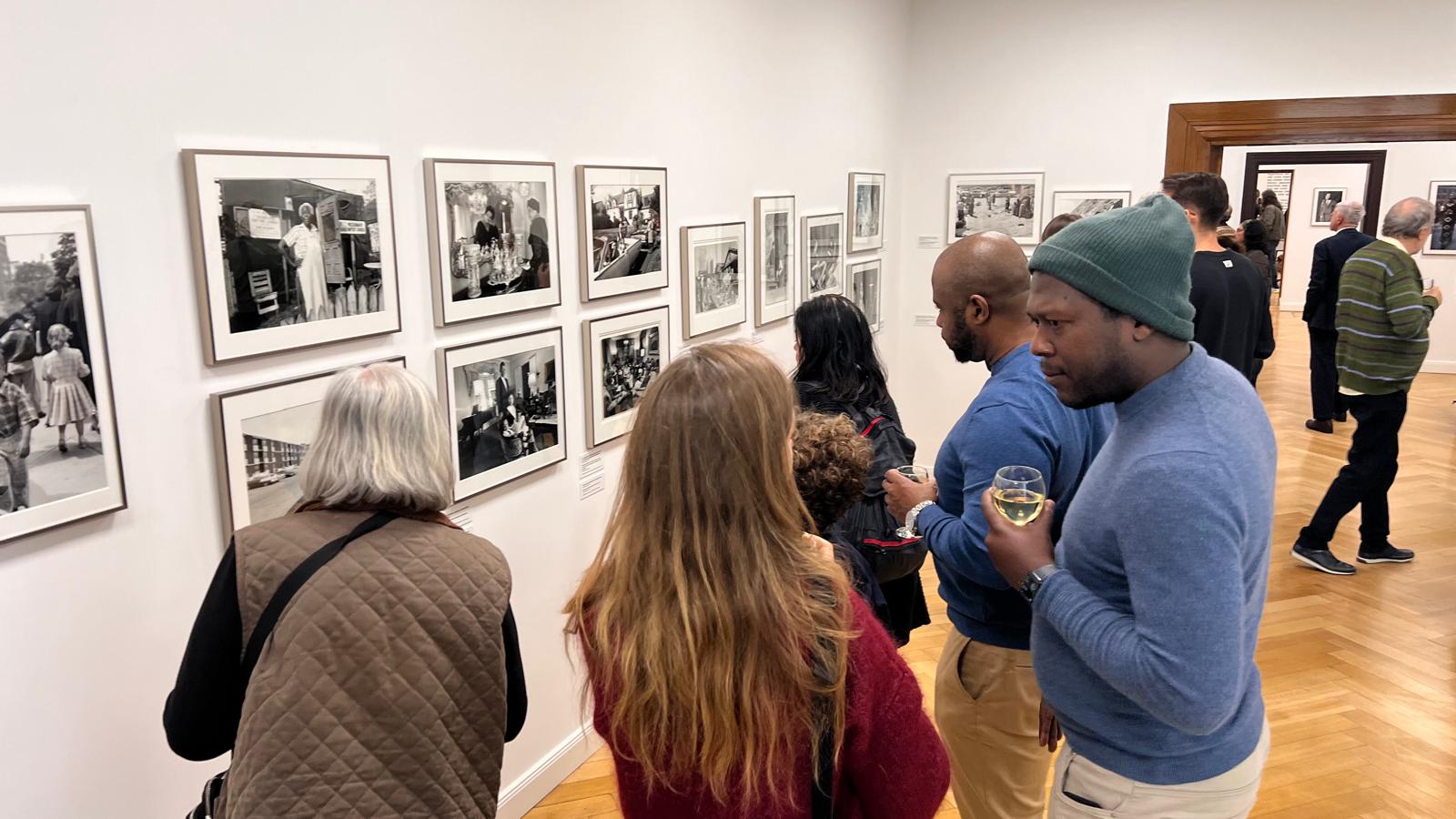 Eröffnung der Sonderausstellung United | Disunited Zahlreiche Besucher schauen sich schwarz-weiß Fotografien der neuen Sonderausstellung an.